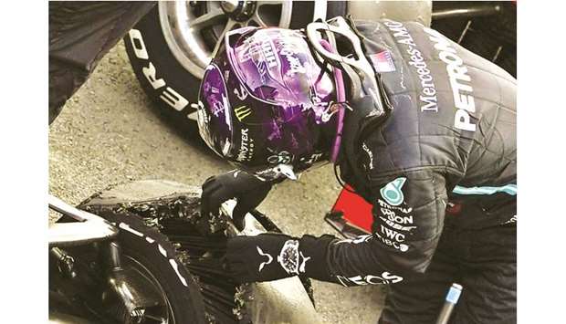 Mercedesu2019 Lewis Hamilton looks at his tyre after winning the British Grand Prix at the Silverstone Circuit on Sunday with a puncture on the final lap. (Reuters)