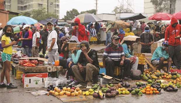 Sellers wait for customers under the rain at the Coche wholesale market amid coronavirus (Covid-19) disease outbreak in Caracas.