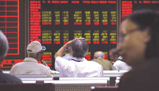 Investors watch stock market movements at a securities company in Beijing. The Composite closed up 0.2% to 3,377.56 points yesterday.