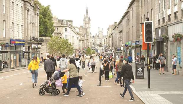 Residents walk in central in Aberdeen, eastern Scotland yesterday following the announcement that a local lockdown has been imposed on the city after a spike in the number of coronavirus cases.