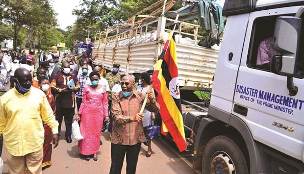 File photo shows Ugandau2019s Prime Minister Ruhankana Rugunda (centre) flanked by ministers, walking next to trucks carrying relief goods to be distributed to civilians affected by the lockdown, as part of measures to prevent the potential spread of Covid-19, in Kampala.