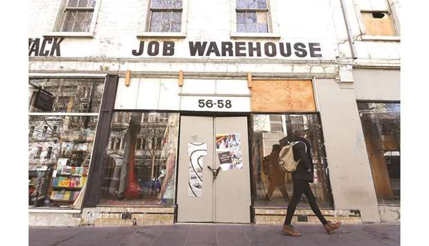 A pedestrian walks past a closed shop as the city operates under lockdown restrictions in Melbourne, Australia.