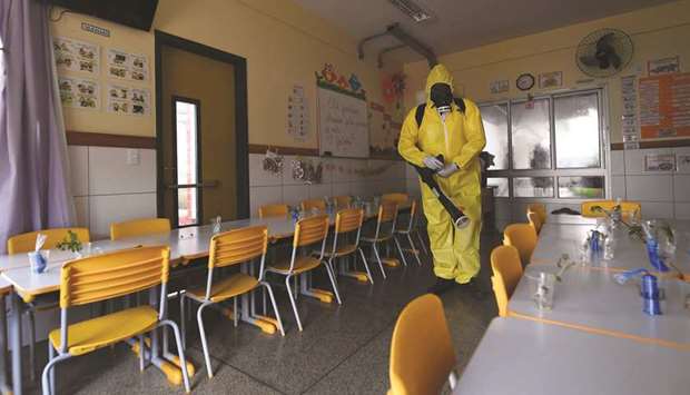 A Federal Districtu2019s employee disinfects a public school as a measure against the spread of the new coronavirus in Brasilia.