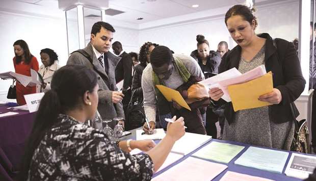 A New York Department of City Administrative Services representative (left), speaks with job seekers during a job fair in New York (file). Nonfarm payrolls increased by 1.763mn jobs last month after a record rise of 4.791mn in June.
