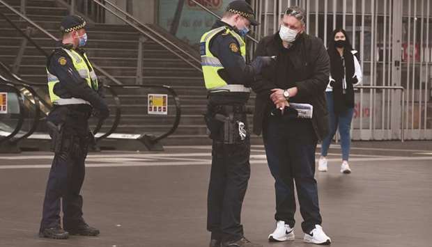 A Protective Services Officer speaks to a man at the Southern Cross Station in Melbourne.
