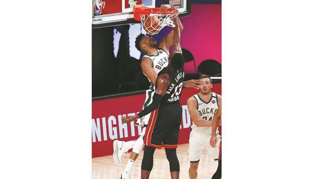 Milwaukee Bucksu2019 Giannis Antetokounmpo (left) dunks to score a basket against Miami Heatu2019s Bam Adebayo (centre) during the game at The Arena in Lake Buena Vista, Florida, United States. (USA TODAY Sports)