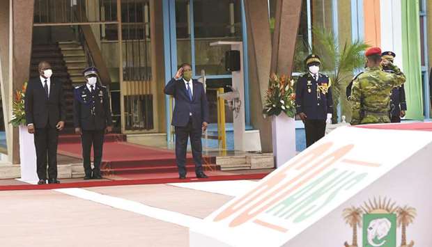 Ivory Coast President Alassane Ouattara, flanked by Ivorian Prime Minister Hamed Bakayoko, salutes during a ceremony to mark the 60th anniversary of the countryu2019s independence at the presidential palace in Abidjan, yesterday.