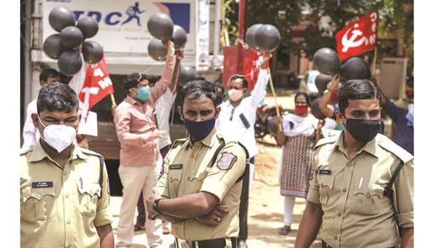 A police personnel wearing a facemask stands guard as members of Communist Party of India (Marxist) CPM hold black balloons and black ribbons as they protest against the increase in coronavirus cases in Telangana, Hyderabad, yesterday.