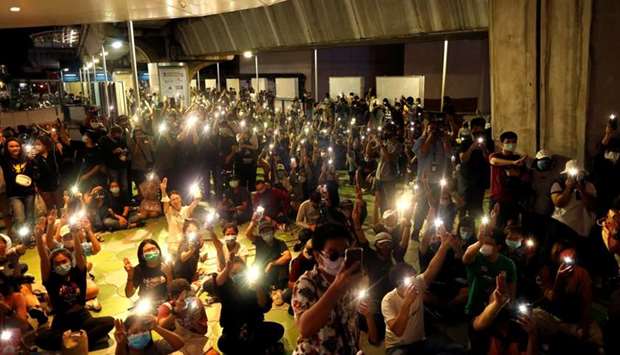 Protesters hold up their phones during a demonstration, after activist leaders arrested on Friday and held overnight in connection with recent anti-government protests were granted a bail, in Bangkok, Thailand