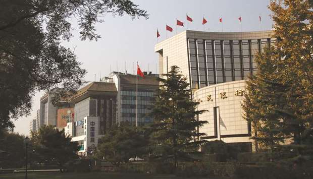 The Peopleu2019s Bank of China headquarters (right) in the financial district of Beijing. Chinau2019s banks need about $500bn in fresh liquidity this month to roll over existing debt and buy government bonds, complicating the PBoCu2019s efforts to exit crisis measures.