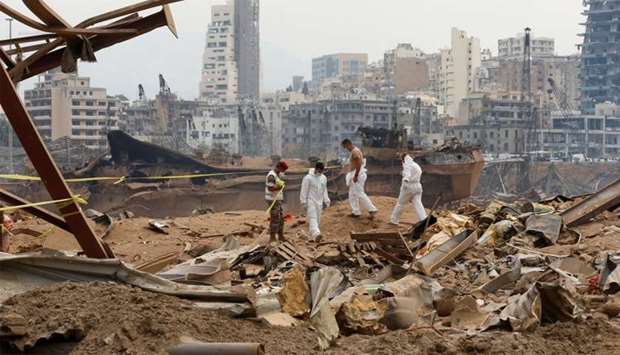 Members of forensic team walk near rubble at the site of Tuesday's blast, at Beirut's port area, Lebanon