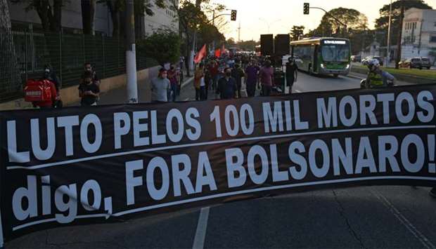 Health union members hold a banner reading u201cMourning for the 100,000 dead. I say, Bolsonaro out!u201d as they pay tribute to the nearly 100,000 victims of the novel coronavirus and protest against Brazil's President Jair Bolsonaro for the way he is handling the pandemic, in Sao Paulo, Brazil,