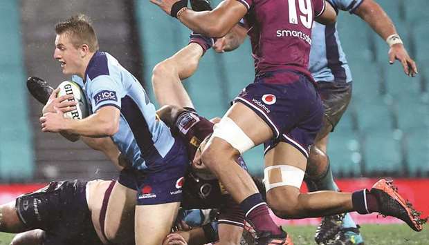 Joey Walton (left) of the NSW Waratahs is tackled by James Ou2019Connor from the Queensland Reds during the Super Rugby match at the Sydney Cricket Ground (SCG) yesterday. (AFP)
