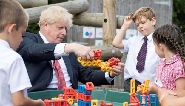 Britain's Prime Minister Boris Johnson plays with toys as students look on during a visit to The Discovery School in Kent, Britain July 20, 2020.