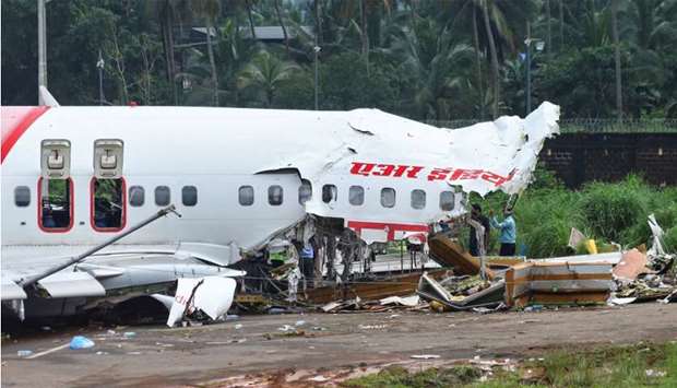 Officials inspect the site where a passenger plane crashed when it overshot the runway at the Calicut International Airport in Karipur