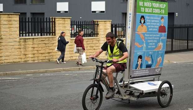 In a promotion funded by Calderdale Council, Phil Mearns rides his ad bike displaying advice on how to slow the spread of the coronavirus through the streets of Halifax in northern England
