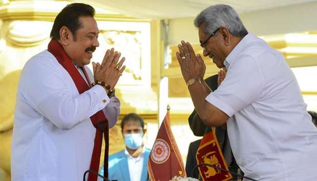 Sri Lakan President Gotabaya Rajapaksa (R) swears in his elder brother Mahinda Rajapaksa (L) as Sri Lanka's new Prime Minister at the sacred Kelaniya Raja Maha Buddhist temple, outside the capital Colombo