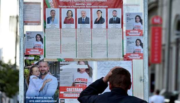 A man reads pre-election posters  in central Minsk
