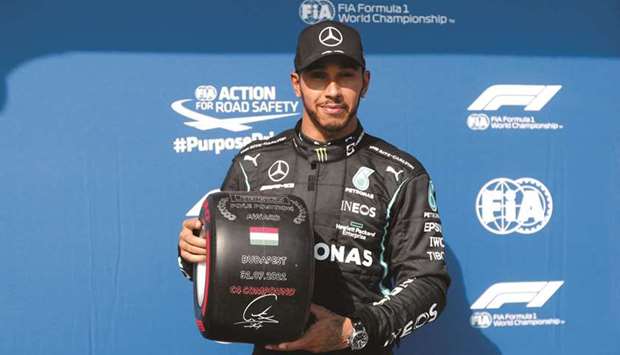Mercedesu2019 British driver Lewis Hamilton poses with the pole position award after winning the the qualifying session at the Hungaroring race track in Mogyorod near Budapest yesterday. (AFP)