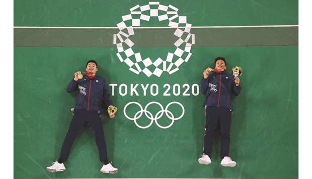 Taiwanu2019s Lee Yang (right) and Taiwanu2019s Wang Chi-lin pose on the court with their menu2019s doubles badminton gold medals during the Tokyo 2020 Olympic Games at the Musashino Forest Sports Plaza in Tokyo yesterday. (AFP)