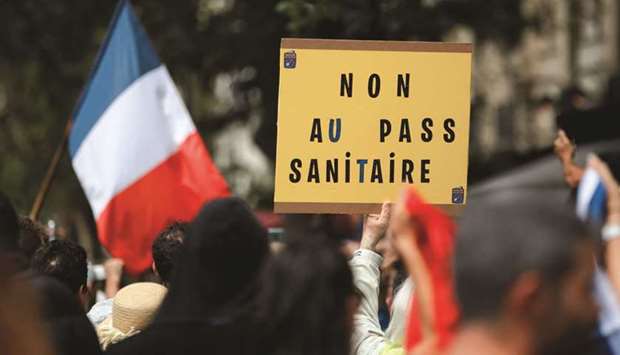 A protester holds a sign reading u201cNo to health passu201d during a demonstration called by the u201cyellow vestu201d (gilets jaunes) movement against Franceu2019s restrictions, including a compulsory health pass, to fight Covid outbreak, in Paris yesterday. (Reuters)