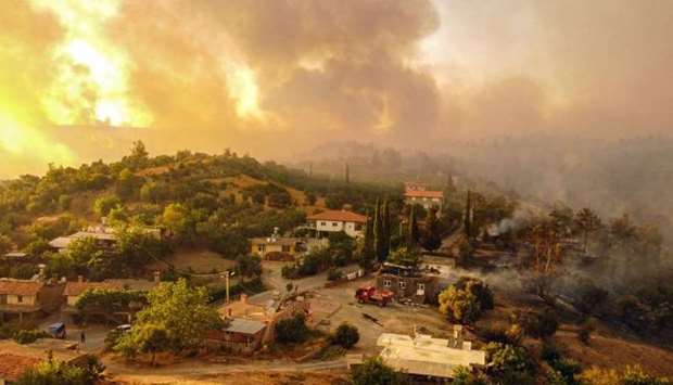 This aerial photograph shows houses surrounded by a wildfire which engulfed a Mediterranean resort region on Turkey's southern coast near the town of Manavgat, on July 30