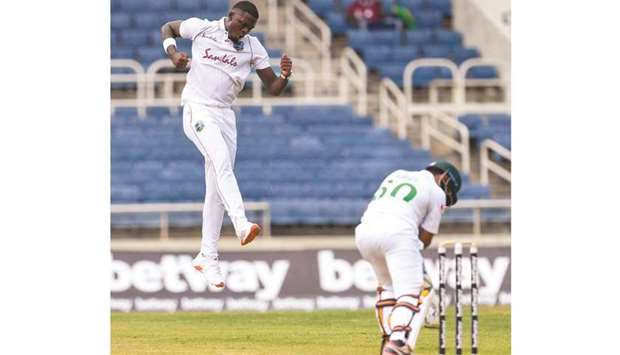 Jayden Seales (left) of West Indies celebrates the dismissal of Abid Ali (right) of Pakistan during Day 1 of the 1st Test at Sabina Park, Kingston, Jamaica, yesterday. (AFP)