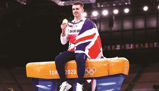 Gold medallist Max Whitlock of Britain poses with his medal whilst sitting on the pommel horse yesterday. (Reuters)