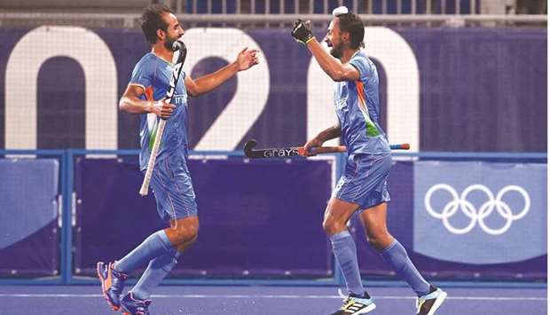 Indiau2019s Hardik Singh (R) celebrates with a teammate after scoring against Britain during their menu2019s quarter-final match of the Tokyo 2020 Olympic Games field hockey competition, at the Oi Hockey Stadium in Tokyo, on August 1, 2021.(Photo by CHARLY TRIBALLEAU / AFP)