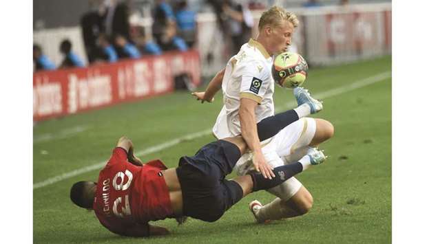 Lilleu2019s Reinildo (left) falls as he vies for the ball with Niceu2019s Kasper Dolberg during Ligue 1 match at the Pierre Mauroy Stadium in Villeneuve du2019Ascq, near Lille, France, yesterday. (AFP)