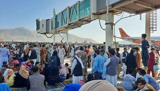 Afghans crowd at the tarmac of the Kabul airport on August 16, 2021.