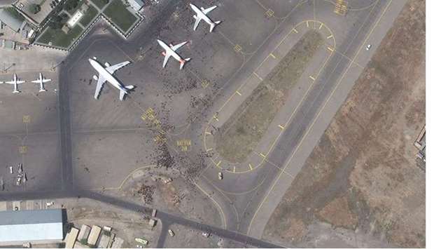 This handout satellite image released by Maxar Technologies shows a crowds of people on the tarmac during the chaotic scene underway at Hamid Karzai International Airport in Afghanistan as thousands of people converged on the tarmac and airport runways as countries attempt to evacuate personnel from the city yesterday. (AFP)