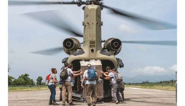 Personnel from the Team Rubicon unload a US helicopter after arriving to assist quake victims in Les Cayes, Haiti.