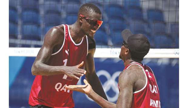 Cherif Younousse (left) and Ahmed Tijan of Qatar celebrate a point during the beach volleyball Round of 16 match at the Tokyo Olympic Games. (Reuters)