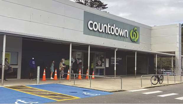 People stand in line outside a grocery store as a lockdown to curb the spread of cases of Covid-19 remains in place in Wellington.
