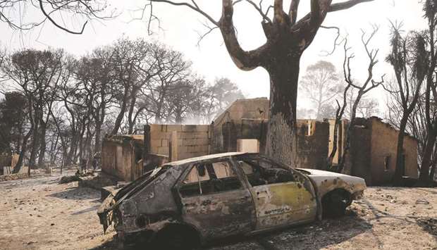 A general view of a burnt car as a wildfire continues near the village of Labiri, near Patras in Greece yesterday. (Reuters)