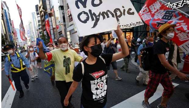 Anti-Olympics group's members wearing protective face masks display banners during their protest march, amid the coronavirus disease pandemic, at Shinjuku district in Tokyo, Japan yesterday. REUTERS