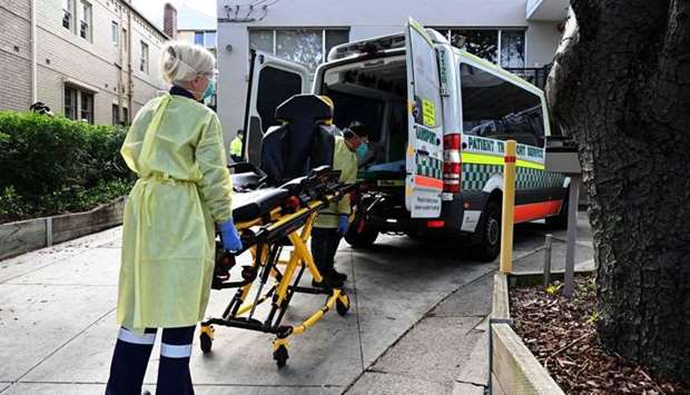 Health workers take out stretchers from an ambulance at the Hardi Aged Care Nursing Home Facility in Summers Hill suburb of Sydney, after at least 12 cases of Covid-19 infections were reported at the facility. AFP