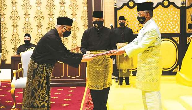 Malaysiau2019s incoming Prime Minister Ismail Sabri Yaakob (left) receiving documents from King Al Sultan Abdullah Sultan Ahmad Shah before taking the oath as the countryu2019s new leader at the National Palace in Kuala Lumpur.