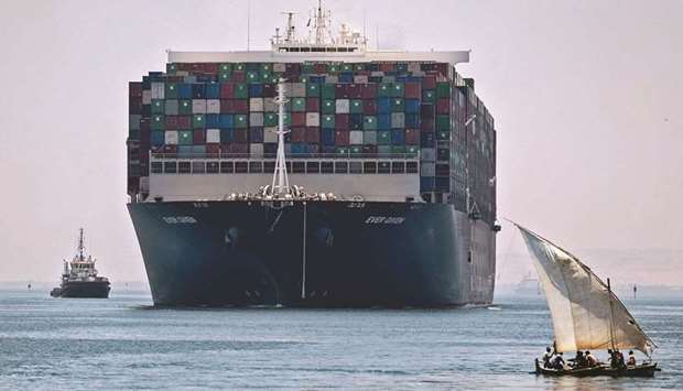 A view of the Panama-flagged MV u2018Ever Givenu2019 container ship sailing near a felucca along Egyptu2019s Suez Canal near the canalu2019s central city of Ismailia, as it departs from the waterway after Egyptian authorities and the Japanese owner agreed a compensation deal over the March 2021 blockage.