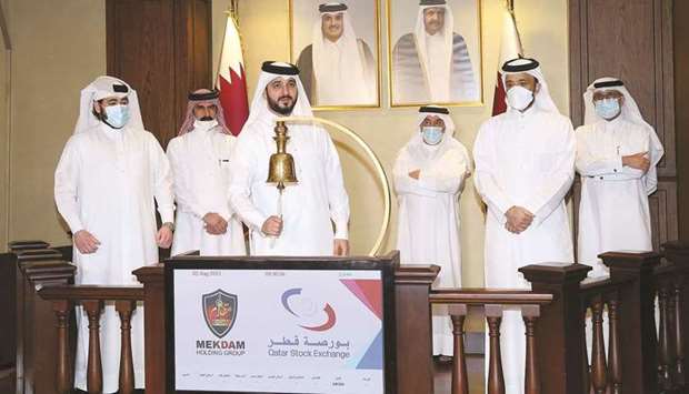 Sheikh Mohamed rings in bell to mark Mekdam's foray into the Qatar Stock Exchange as others look on.