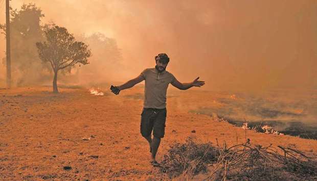 A man walks away from an advancing fire in Mugla, Marmaris district, yesterday.