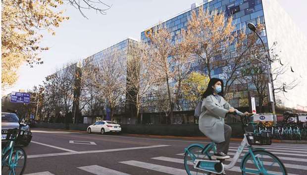 A woman rides a bicycle past the headquarters of Didi Chuxing in Beijing. Didi Global suspended plans to expand in Europe partly because of government concerns over how the Chinese ride-hailing company handles passenger data.