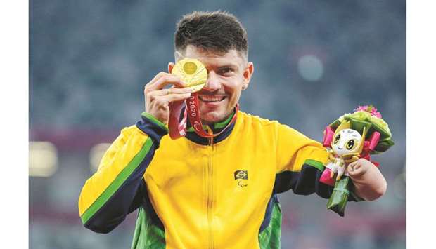 Gold Medallist Petrucio Ferreira Dos Santos of Brazil poses during the medal ceremony for the menu2019s 100 T47 final at the Tokyo Paralympics yesterday. (Reuters)