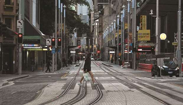 A girl wearing a face mask walking through the empty streets of the central business district in Sydney during the lockdown.