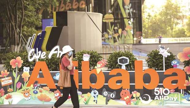 A person walks past a sign at the Alibaba Group Holding headquarters in Hangzhou, China. Alibaba reported revenue that missed estimates, suggesting plans to hike spending in pursuit of growth have yet to gain traction.