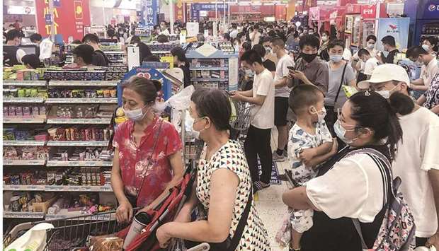 People buy items at a supermarket in Wuhan, in Chinau2019s central Hubei province, as authorities said they would test its entire population for Covid-19 after the central Chinese city where the coronavirus emerged reported its first local infections in more than a year.