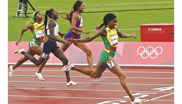 Jamaicau2019s Elaine Thompson-Herah (right) crosses the finish line to win the womenu2019s 200m final during the Tokyo 2020 Olympic Games in Tokyo yesterday. (AFP)