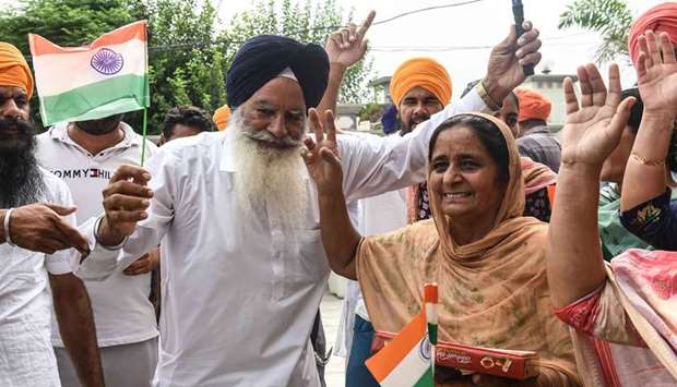 Father Baldev Singh along with his wife Sukhjinder Singh and relatives of hockey player Gurjant Singh celebrate at Klehara village, Amritsar, India.