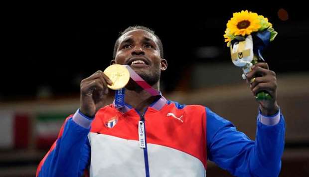 Gold medallist Cuba's Julio La Cruz celebrates on the podium with his medal after the men's heavy (81-91kg) boxing final bout during the Tokyo 2020 Olympic Games at the Kokugikan Arena in Tokyo